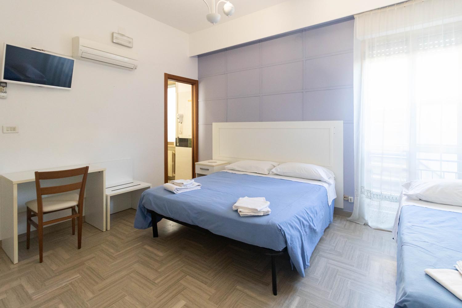 Una camera dell'Hotel Altamira con i letti rivestiti in azzurro